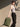 Woman carrying the Flow Everyday Pack 22.5L in green by the handle