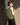 Person wearing a green backpack against a neutral background