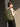 Person wearing a green backpack against a neutral background