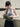 Woman holding a green waist bag against a neutral background