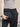 Person holding a black tech bag with a neutral background