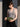 Woman holding a green pouch against a dark background