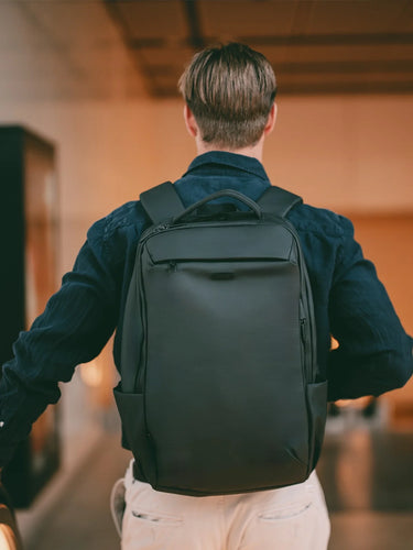 Man wearing the Transit Anti-Theft Pack 26L in black at an airport