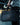 Person holding a black duffel bag with a blurred indoor gym background
