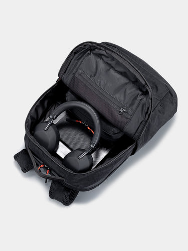 Black backpack with a gaming headset inside on a light gray background
