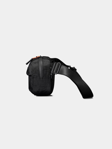 Black sling bag on a light gray background