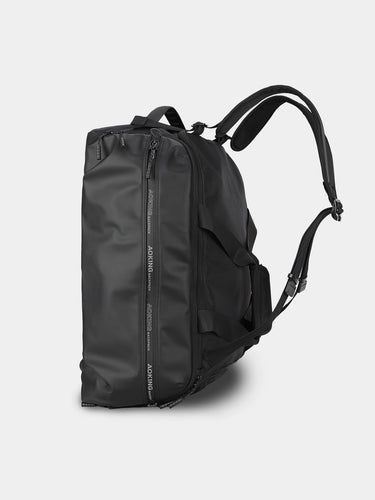 Black duffle backpack on a light gray background