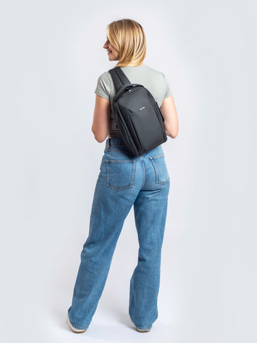 Woman wearing the Everyday Anti-Theft Sling 7L on her back, seen from behind